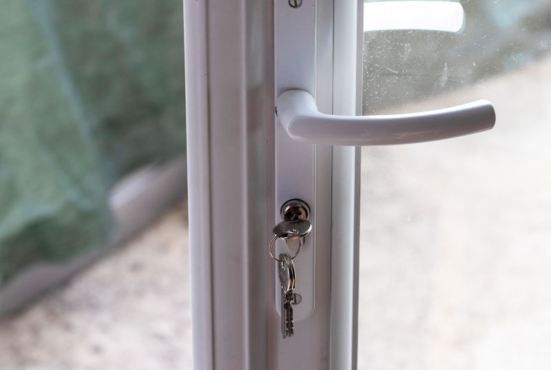 Close up view of a patio door lock with a key in it