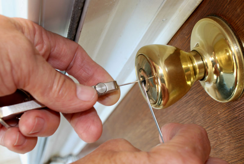 Locksmith picking a gold lock